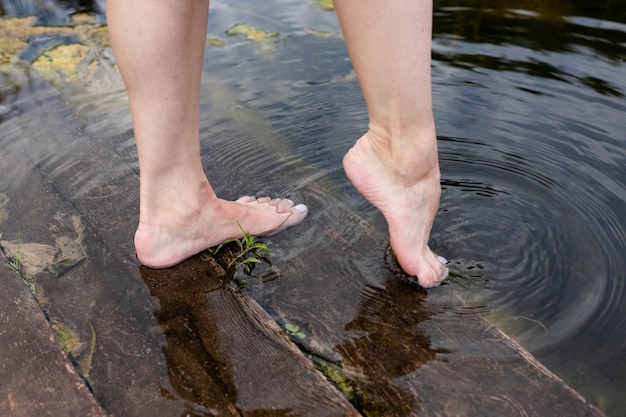 Piedi immersi nell'acqua limpida Piedi nell'acqua Selfie di gambe e piedi nudi Vacanza in vacanza estiva