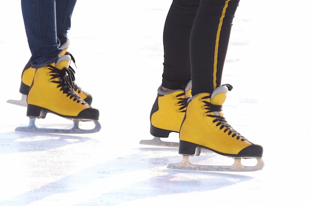 Piedi in pattini rossi su una pista di pattinaggio. Sport e divertimento. Riposo e vacanze invernali.