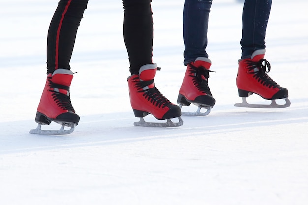 Piedi in pattini rossi su una pista di pattinaggio sul ghiaccio