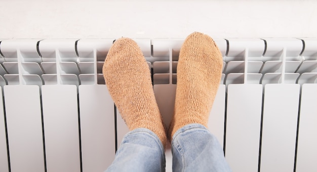 Piedi maschili con calzini sul radiatore