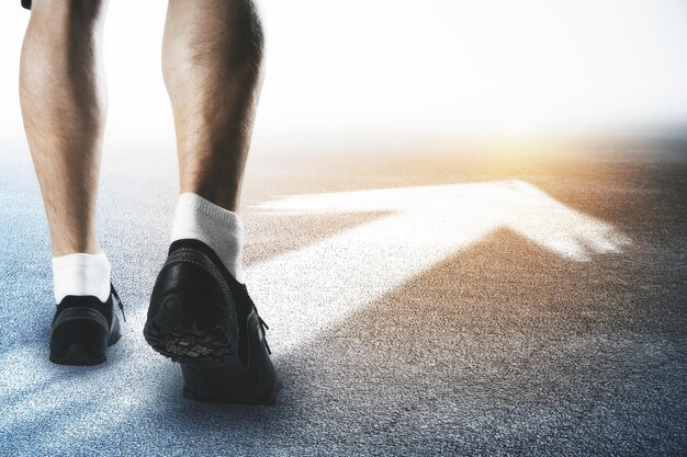 Piedi maschili con frecce Sport e concetto in avanti