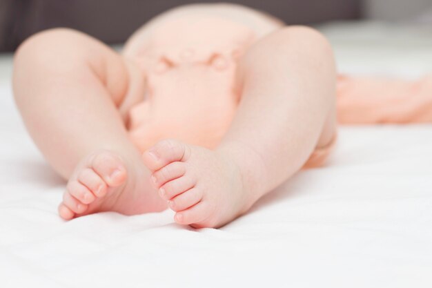 Piedi neonato sdraiato su una coperta bianca.