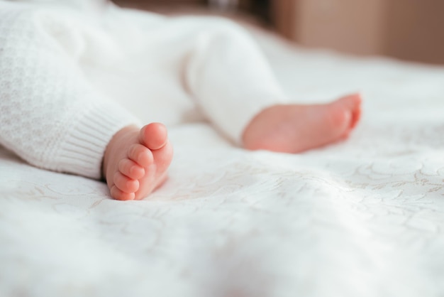 Piedi nudi del bambino sul primo piano del letto