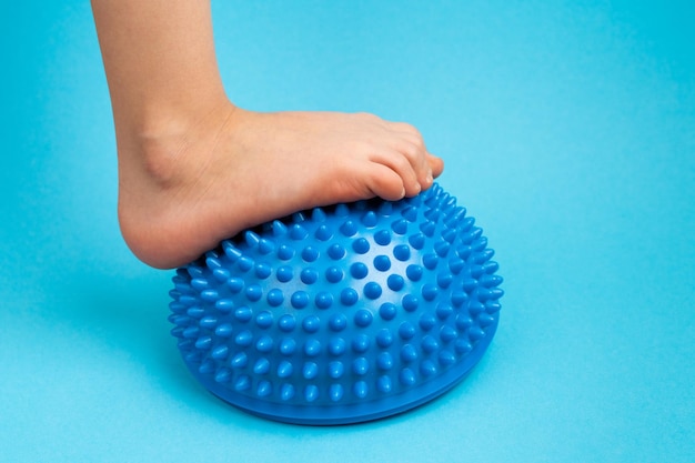 Piedi per bambini con bilanciatore blu su fondo azzurro trattamento e prevenzione dei piedi piatti valgo deformità del piede