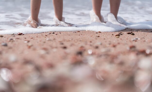 Piedi per bambini in acqua di mare sulla spiaggia