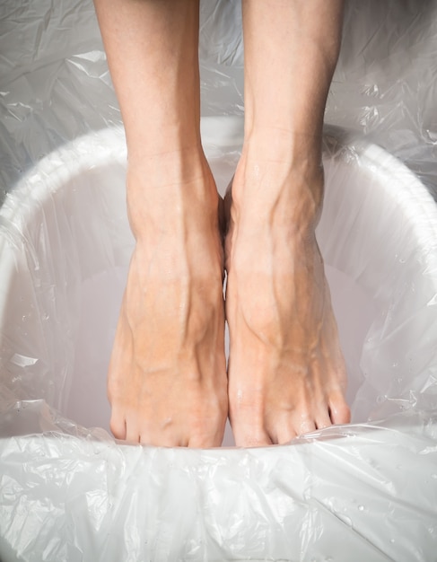 Piedi stanchi, piedi femminili in un bagno rilassante.