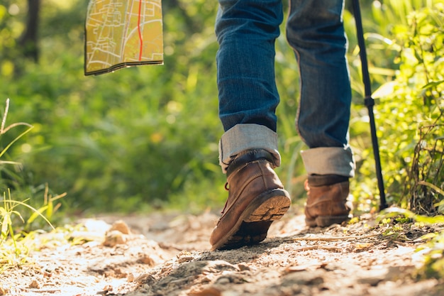 Piedi uomo escursionismo all'aperto e foresta sullo sfondo