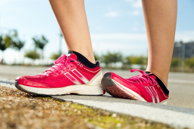 Piedini della donna in scarpe da ginnastica