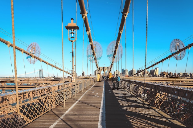 Pieno di turista che cammina sul ponte di Brooklyn in una bella giornata, New York