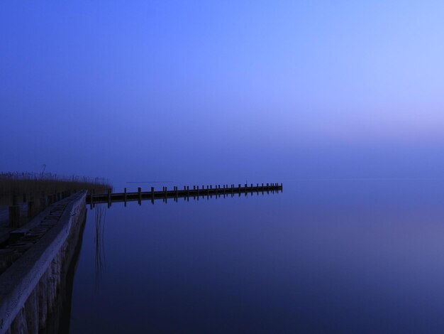 Pier dal lago calmo contro il cielo durante il tramonto
