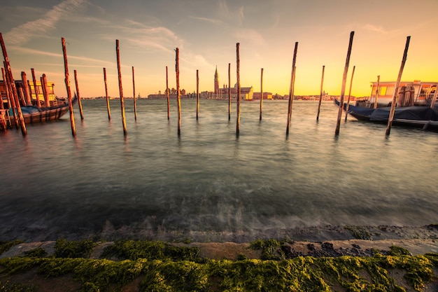 Pier nel canale di Venezia con la chiesa di San Giorgio Maggiore sul retro, Veneto, Italia.