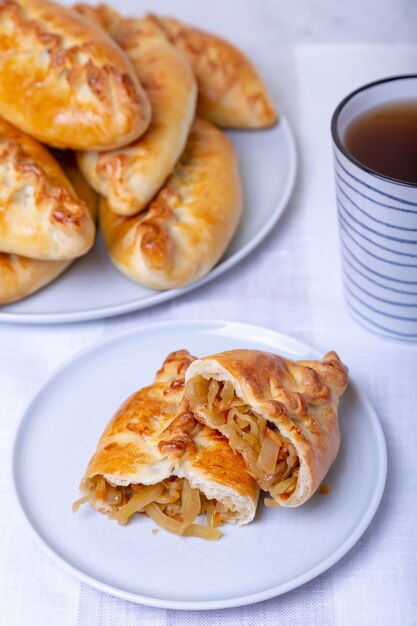 Pies pirozhki con cavolo e tazza da tè