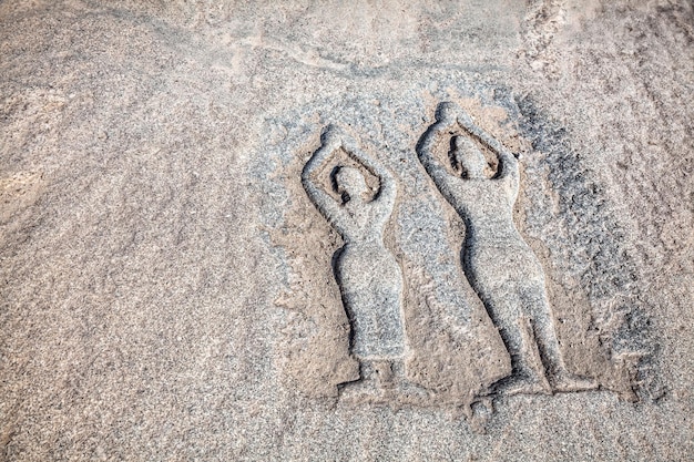 Pietra con persone che praticano yoga ad Hampi