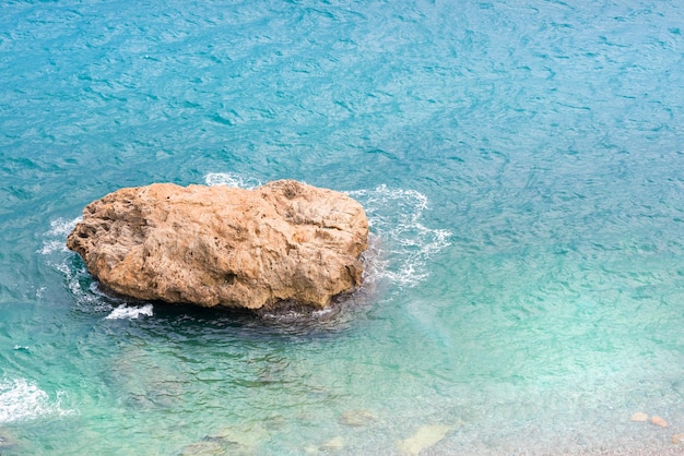 Pietra della roccia nel mare blu