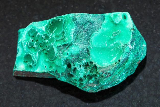 Pietra grezza di malachite verde su sfondo scuro