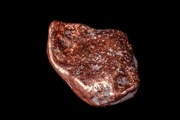 Pietra minerale macro di una pepita di rame su un microclino su sfondo nero