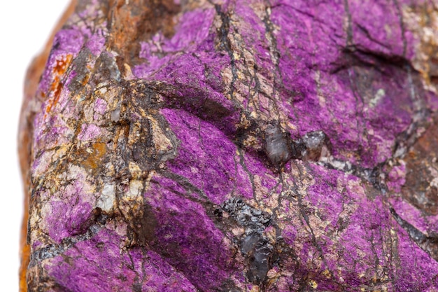 Pietra minerale macro purpureus purpurite viola nella razza uno sfondo bianco