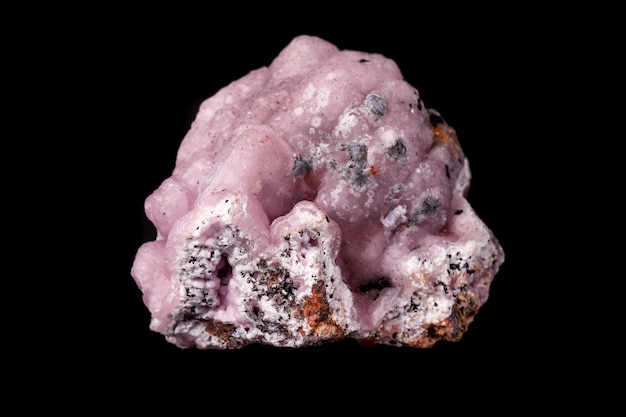 Pietra minerale Smithsonite rosa macro su microclino su sfondo nero