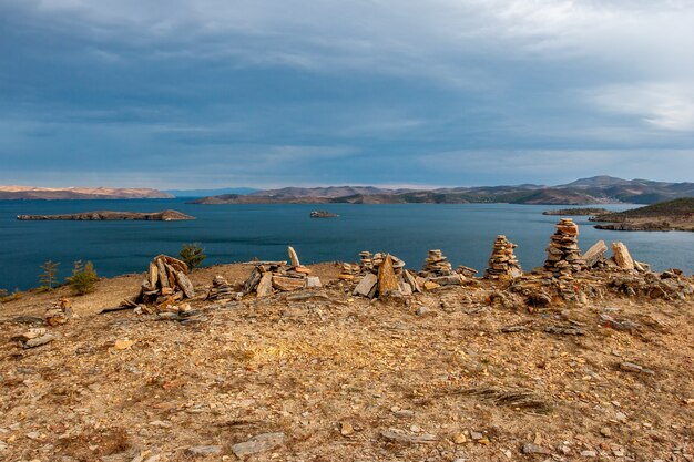 Pietre ammucchiate dalle piramidi e vista sul lago Baikal