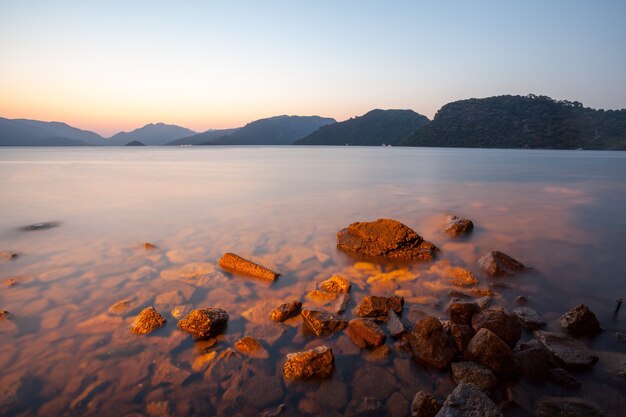 Pietre su uno sfondo di mare sfocato con vista sulle montagne