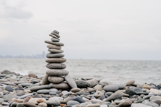 Pietre sulla spiaggia a forma di piramide. equilibrio e meditazione, spazio per il testo