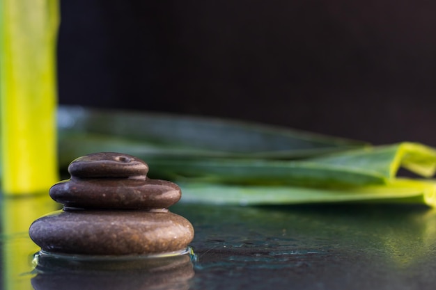 Pietre Zen con acqua su sfondo nero con foglie