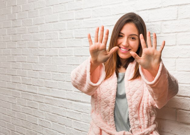 Pigiama da portare della giovane donna che mostra numero dieci