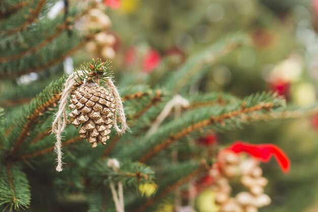 Pigna dorata dipinta sull'albero di Natale Decorazione fai da te Concetto ambientale Messa a fuoco selettiva