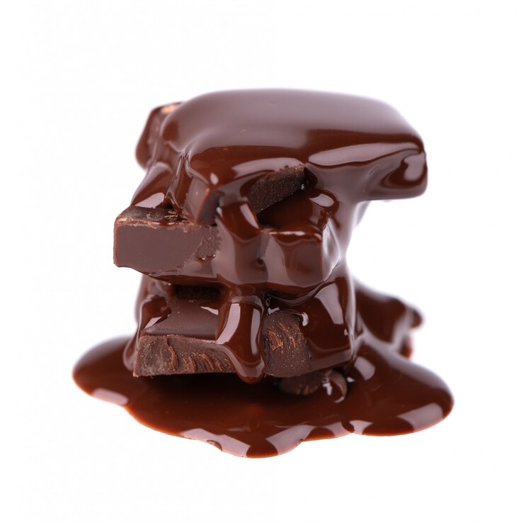 Pila dei pezzi del cioccolato e sciroppo di cioccolato isolati. Avvicinamento.