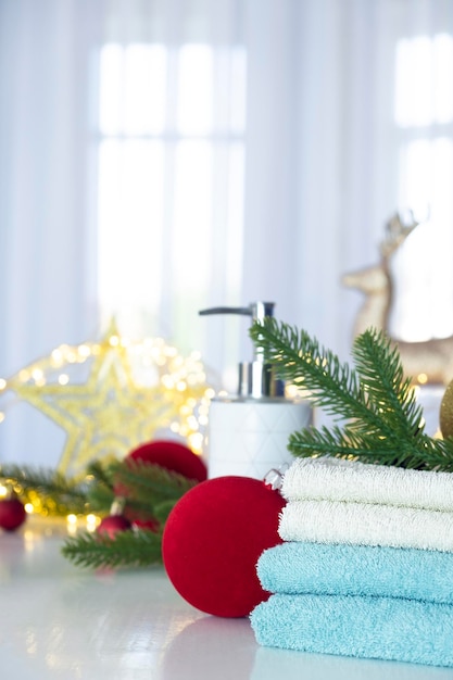 Pila di asciugamani blu e bianchi piegati sul tavolo rami di abete Palle di Natale e luci di Natale Trattamento SPA o salone di bellezza relax e benessere nella variante Natale o Capodanno