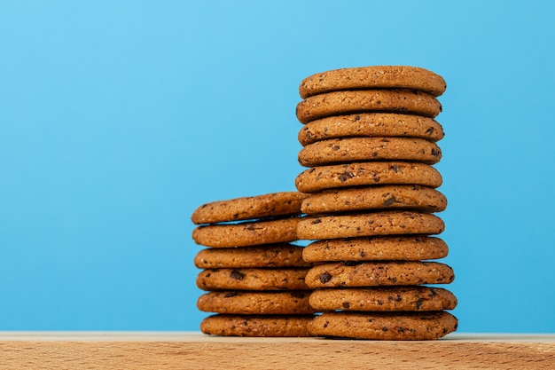 Pila di biscotti al cioccolato su sfondo blu vista frontale