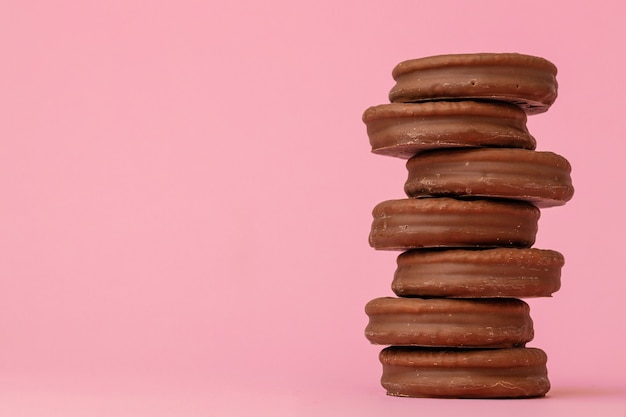 Pila di biscotti al cioccolato su sfondo rosa