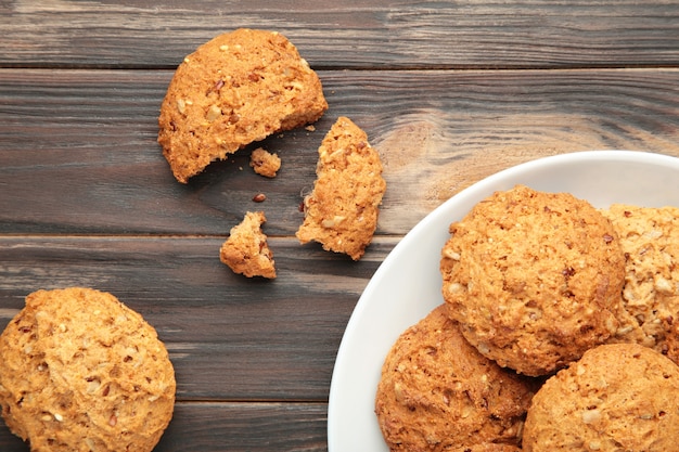 Pila di biscotti sulla piastra su sfondo marrone.