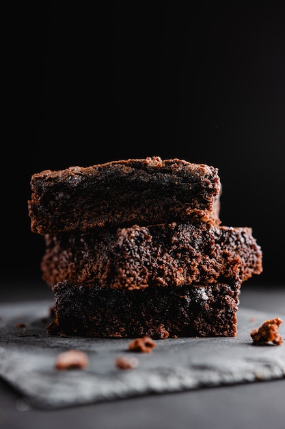 Pila di brownie al cioccolato sulla pietra nera dell'ardesia