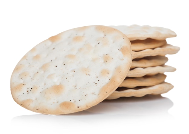 Pila di cracker salati croccanti organici rotondi su fondo bianco