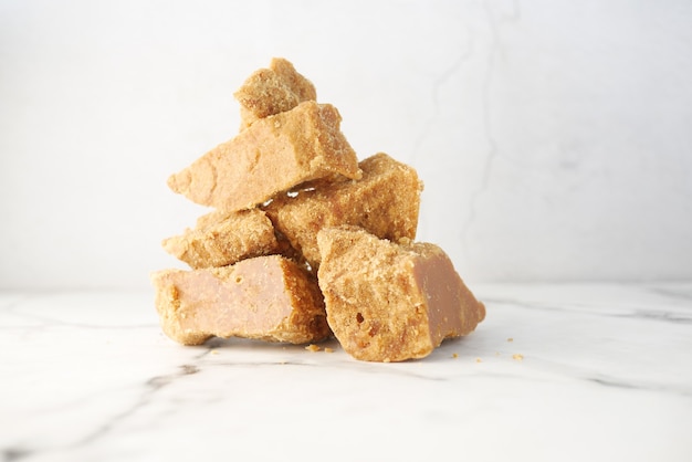 Pila di cubo di zucchero di canna tradizionale jaggery sul tavolo