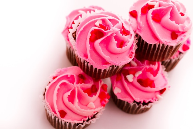 Pila di cupcakes rosa con anello di fidanzamento in cima.