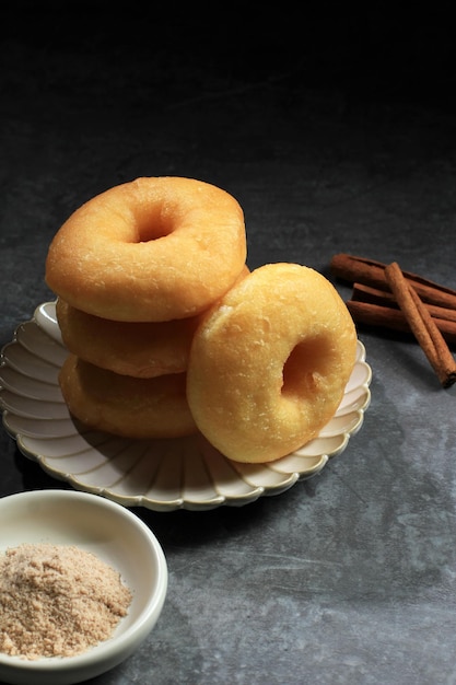 Pila di deliziose ciambelle alla cannella sul tavolo grigio cemento