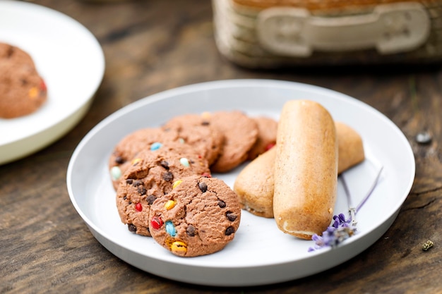 Pila di deliziosi biscotti con scaglie di cioccolato su una piastra bianca con altra torta