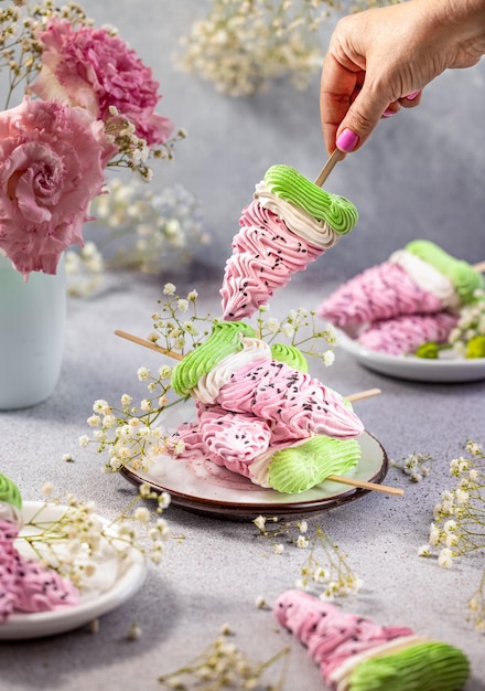 Pila di deliziosi marshmallow colorati fatti in casa sotto forma di fette di anguria su sfondo grigio