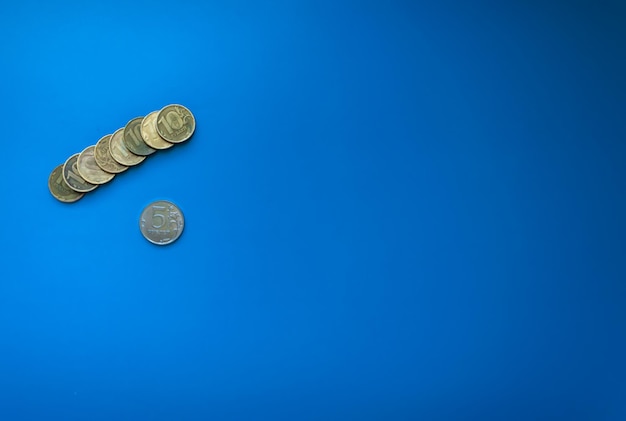 pila di dieci rubli monete leeit sulla sinistra su sfondo blu isolato spazio libero per il testo russo