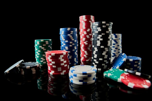 Pila di fiches del casinò isolate su sfondo nero riflettente