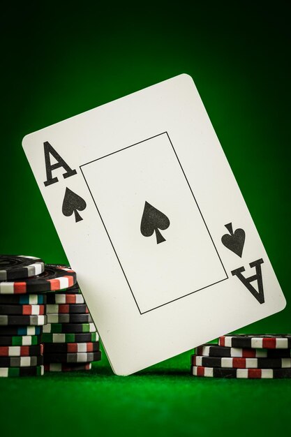 Pila di fiches e due assi sul tavolo sul panno verde - concetto di gioco di poker