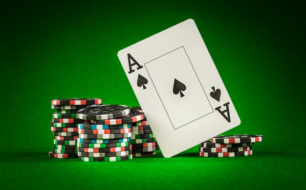 Pila di fiches e due assi sul tavolo sul panno verde - concetto di gioco di poker