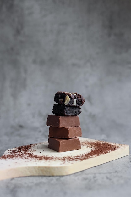 Pila di gustoso cioccolato e brownie con cacao in polvere sopra il legno