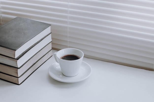 Pila di libri e tazza di caffè in tonalità bianche pure Concetto di giornata mondiale del libro