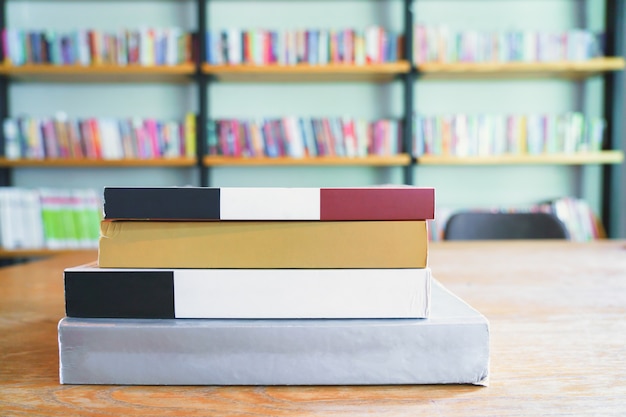 Pila di libri sul tavolo nella sala delle biblioteche. Affari, istruzione e concetto di ritorno a scuola.