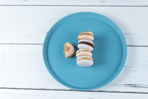 Pila di macarons con ripieno di dulce de leche e ganache al cioccolato accanto a un macaron con un morso