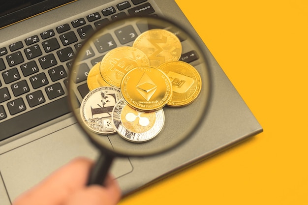 Pila di monete crittografiche con Ethereum in cima, lente d'ingrandimento con impugnatura uomo, valuta cripto finanziaria e foto di sfondo aziendale