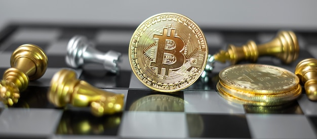 Pila di monete di criptovaluta Bitcoin d'oro e pezzo degli scacchi sulla scacchiera, Crypto è denaro digitale della rete blockchain, viene scambiato utilizzando la tecnologia e lo scambio Internet online. Concetto finanziario